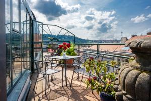 un balcón con sillas y una mesa con flores en Hotel Bologna, en Praga