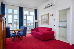 a living room with a red couch and a table at Hotel Bologna in Prague