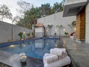 a swimming pool with towels on the side of a house at The Infinity Pool Villa Hotel by DanCenter, Baga Beach, Goa in Arpora