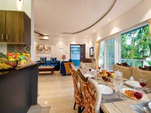 a kitchen and living room with a table and chairs at The Infinity Pool Villa Hotel by DanCenter, Baga Beach, Goa in Arpora