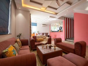 a living room with couches and a table at The Infinity Pool Villa Hotel by DanCenter, Baga Beach, Goa in Arpora