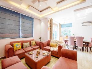 a living room with a couch and a table at The Infinity Pool Villa Hotel by DanCenter, Baga Beach, Goa in Arpora