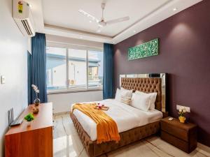 a bedroom with a large bed with purple walls at The Infinity Pool Villa Hotel by DanCenter, Baga Beach, Goa in Arpora +168 photos