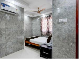 ein kleines Schlafzimmer mit einem Bett und einer Dusche in der Unterkunft Hotel O Tiruvallur Bus Terminal Formerly SK Vinoth Mahal in Tiruvallūr + 15 Fotos