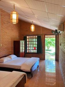 a bedroom with two beds and a window at Nam Cat Tien Retreat in Tân Phú