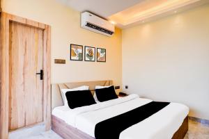 a bedroom with a white bed with black pillows at Super Townhouse Bhangagarh Bus Terminal Formerly The Rudra Inn in Guwahati
