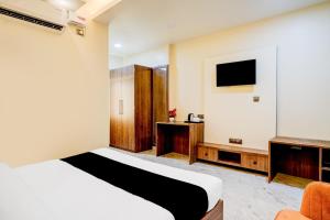 a hotel room with a bed and a tv at Super Townhouse Bhangagarh Bus Terminal Formerly The Rudra Inn in Guwahati +32 photos