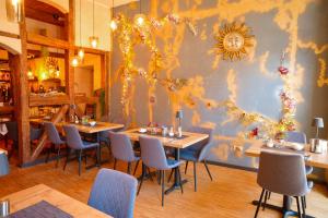 a restaurant with tables and chairs and a wall at Weinstube Sinas Brettl in Nördlingen