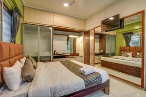 a bedroom with two beds and a bathroom at Hotel Orchard Nest - Pune Sinhgad Road in Pune +24 photos