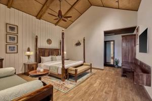 a bedroom with a bed and a couch at WelcomHeritage Akashganga Heritage Hills Resort & Spa 