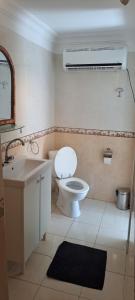 a bathroom with a white toilet and a sink at Riad Diaz Taghazout in Taghazout