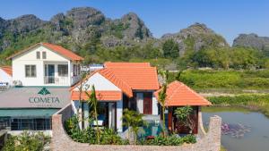 una casa con tetti arancioni su uno specchio d'acqua di Cometa Villas Ninh Binh a Ninh Binh