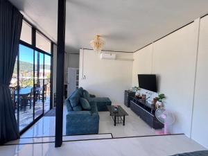 a living room with a couch and a tv at อินทนนท์ บ้านพักเล่าจู Inthanon Laoju House in Ban Na Yang