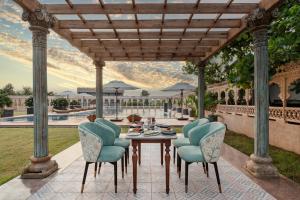 a patio with a table and chairs and a pool at WelcomHeritage Akashganga Heritage Hills Resort & Spa 