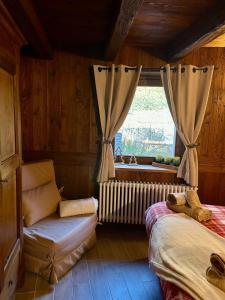 ein Schlafzimmer mit einem Bett und einem Fenster mit einem Heizkörper in der Unterkunft Tsi nos La Salle appartamento con giardino e balcone in La Salle