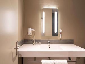 a bathroom with a white sink and a mirror at ibis Paris Tour Montparnasse 15eme in Paris
