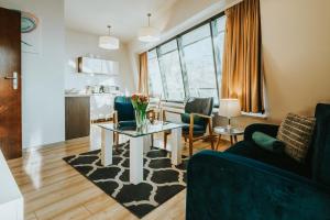a living room with a table with flowers on a rug at VisitZakopane - Cristal Apartment in Zakopane