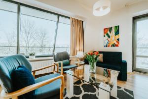 a living room with two chairs and a glass table at VisitZakopane - Cristal Apartment in Zakopane