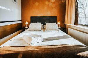 a bedroom with a large bed with towels on it at VisitZakopane - Cristal Apartment in Zakopane