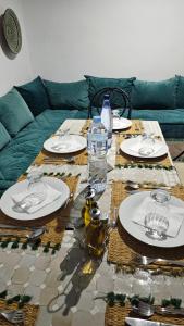 a table with plates and glasses on a couch at Riad Jolie in Marrakesh