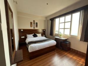 ガントクにあるHotel Freesia Staysの大きなベッドと窓のある寝室