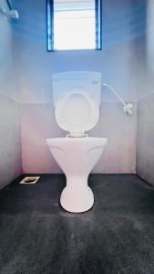 servizi igienici bianchi in una camera con finestra di Samarth Beach Resort a Malwan