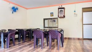 una stanza con un tavolo con sedie viola di Samarth Beach Resort a Malwan