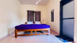 una camera da letto con un letto con una coperta blu di Samarth Beach Resort a Malwan