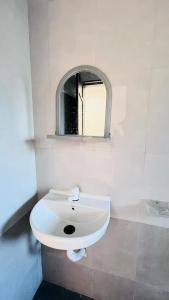 un bagno con un lavandino bianco e uno specchio di Samarth Beach Resort a Malwan Altre 27 foto