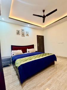 a bedroom with a bed with a ceiling fan at Blue Heaven Farm Villa in Noida