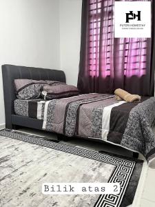 Un pat sau paturi într-o cameră la Puteri Homestay Melaka