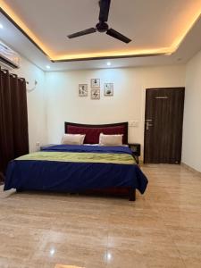 a bedroom with a bed and a ceiling fan at Blue Heaven Farm Villa in Noida