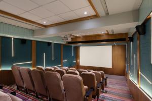 a room with a bunch of chairs and a screen at WelcomHeritage Akashganga Heritage Hills Resort & Spa 