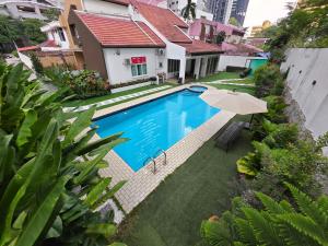 5 Bedroom Villa With Private Pool By Perkasa في كوالالمبور: بيت فيه مسبح ومظله