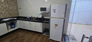 a kitchen with a white refrigerator and a microwave at Casa próximo ao lago - 1 in Boa Esperança +7 photos