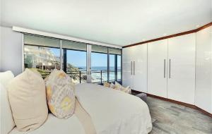 Un dormitorio con una cama blanca y vista al mar. en Luxury Three-Bedroom Oceanfront Residence With Panoramic Coastal Views, en Laguna Beach