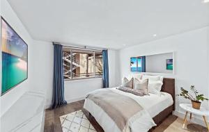 Una habitación blanca con una cama y una ventana en Luxury Three-Bedroom Oceanfront Residence With Panoramic Coastal Views, en Laguna Beach