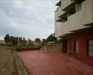 ein Gebäude mit einer roten Auffahrt neben einem Gebäude in der Unterkunft Gesell130 in Villa Gesell