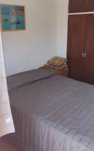 ein Schlafzimmer mit einem Bett und einem Holzschrank in der Unterkunft Gesell130 in Villa Gesell