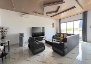 アシニにあるAKl RESIDENCEのソファ2脚と薄型テレビのあるリビングルーム