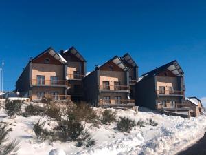 a group of buildings sitting on top of the snow at Casa da Serra - T1 - Penhas da Saúde in Penhas da Saúde