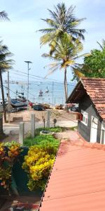 a pathway leading to a beach with a building and palm trees at Private Beach House in Mirissa in Mirissa