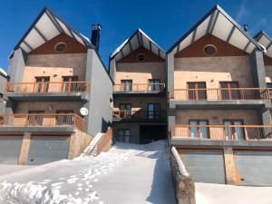 a large building with snow in front of it at Casa da Serra - T1 - Penhas da Saúde in Penhas da Saúde