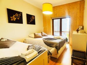 a bedroom with two beds and a window at Casa da Serra - T1 - Penhas da Saúde in Penhas da Saúde