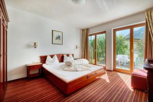 Un dormitorio con una cama y una ventana grande. en Hotel Garni Philipp, en Serfaus 11 fotos más