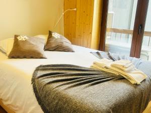 a bed with a blanket on it with a window at Casa da Serra - T1 - Penhas da Saúde in Penhas da Saúde