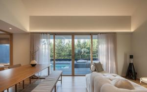 a living room with a white couch and a large window at Kuro Pool Villa Khaoyai in Ban Wang Sai
