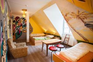 una camera con soffitto giallo e una stanza con tavolo e sedie di Labyrinth Hostel Weimar a Weimar