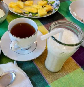 a cup of coffee and a glass of milk on a table at Private Beach House in Mirissa in Mirissa +22 photos