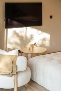 a bedroom with a bed and a table and a tv at Kuro Pool Villa Khaoyai in Ban Wang Sai